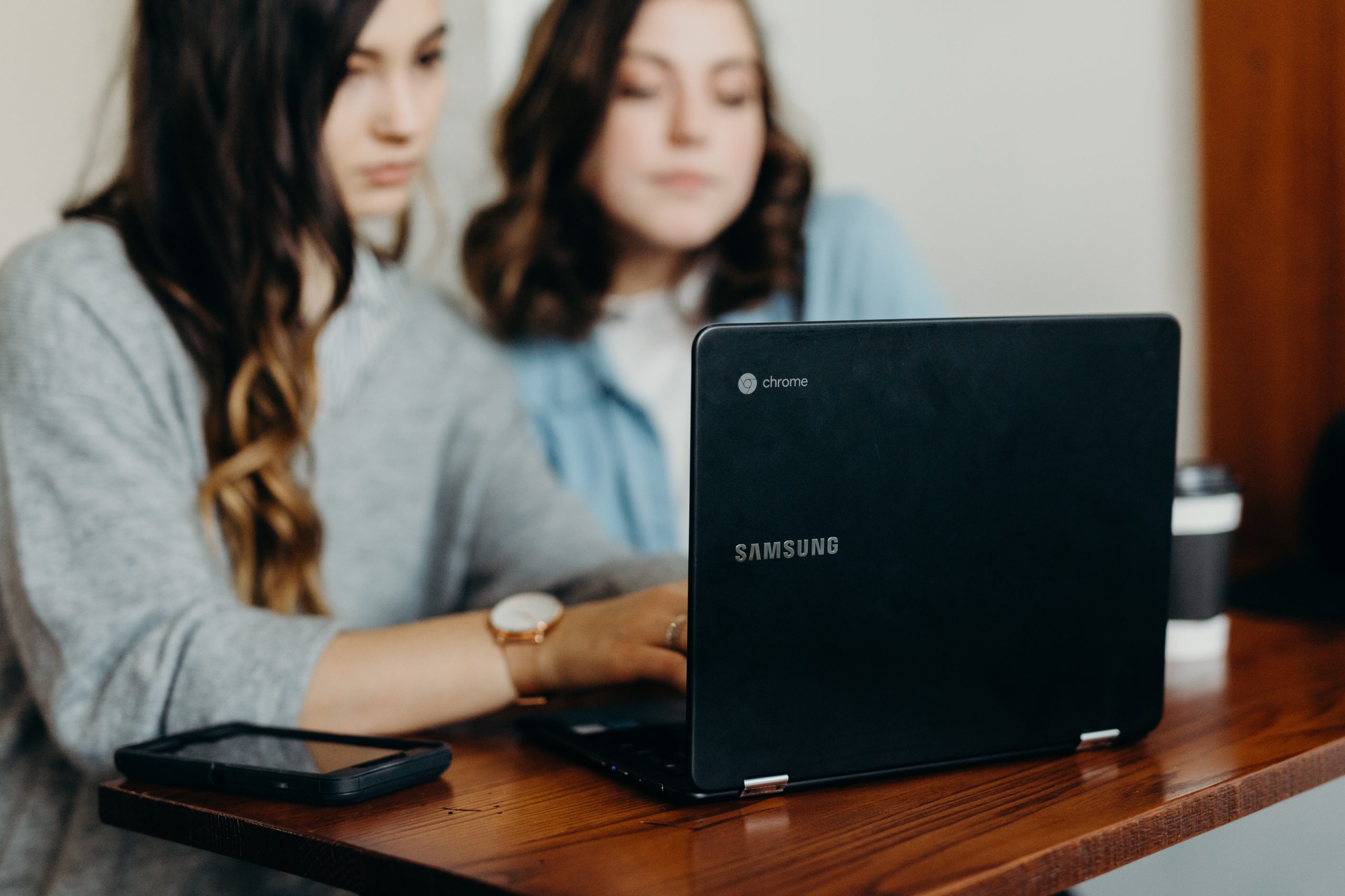 Two students work at a laptop