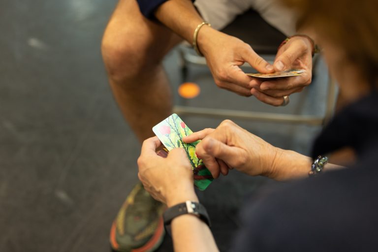 Two people playing cards whilst sitting down, copyright Phil Tragen 2023