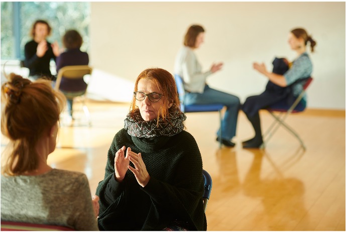 Clapping group seated in a room, copyright Phil Tragen 2023