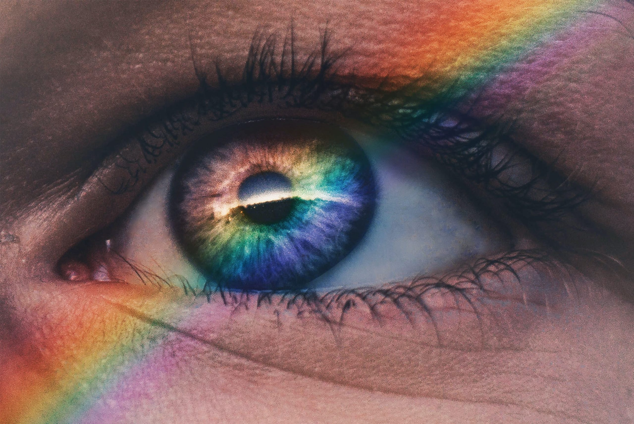 A close up images of an eye with a rainbow over it