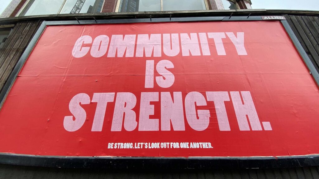 A billboard that reads 'community is strength'.