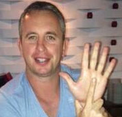 An individual performing the "one-in-five" hand gesture, with the index finger of one hand presented in front of the open palm of the other.