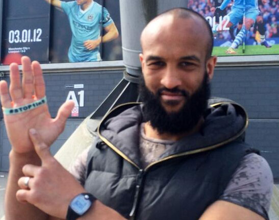 An individual performing the "one-in-five" hand gesture, with the index finger of one hand presented in front of the open palm of the other.