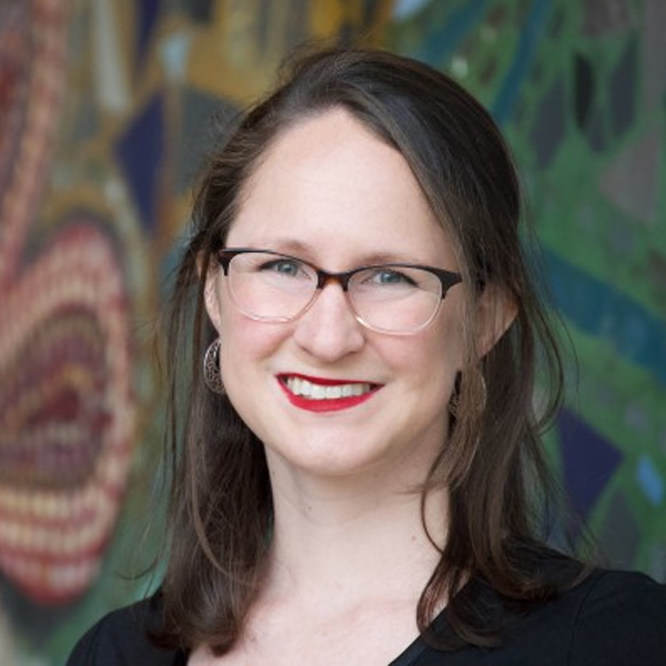 Headshot of Dr. Amy Skjerseth. Amy has dark hair and she is wearing glasses and red lipstick. She is smiling at the camera.