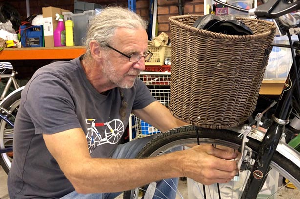 Man fixing a wheel off a shopper bicycle at Preston Pedals