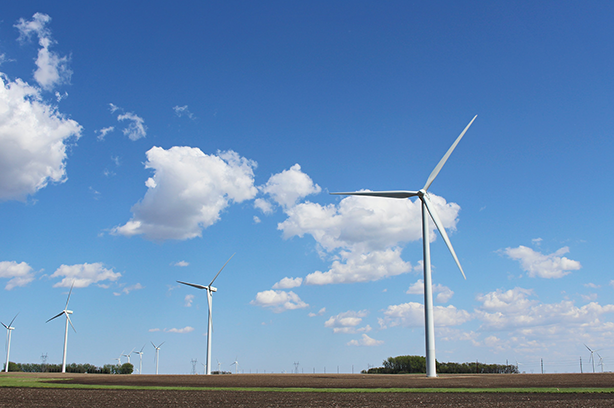 Wind farm towers in a flat field, photo by American Public Power Association on Unsplash