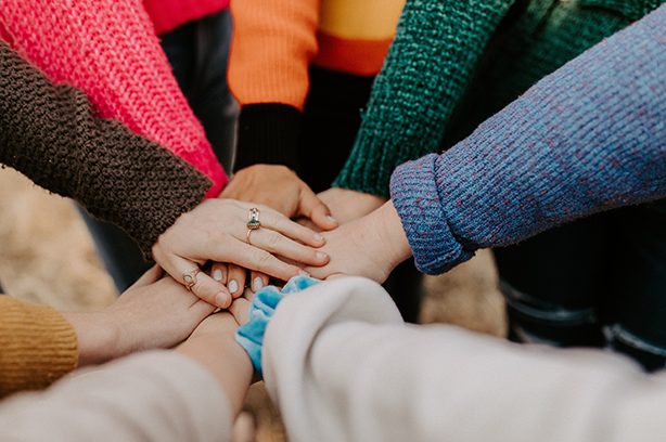 Photo by Hannah Busing on Unsplash, hands coming together in a centre down clap