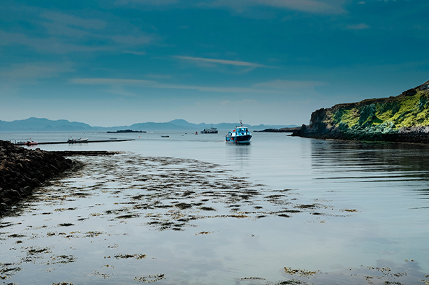 Photo by Ian Ward on Unsplash, a boat coming into the bay on the Isle Of Muck UK