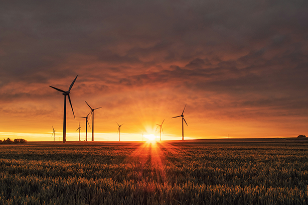 Photo by Karsten Würth on Unsplash, wind turbines in a field during sunrise