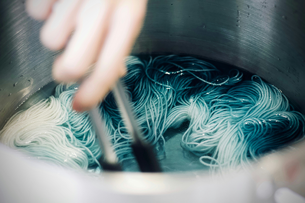 Photo by Jelleke Vanooteghem on Unsplash, yarn being dyed in a metal tub