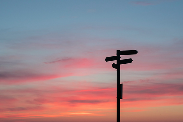 Photo by Javier Allegue Barros on Unsplash, signpost silhouette against a pink sky