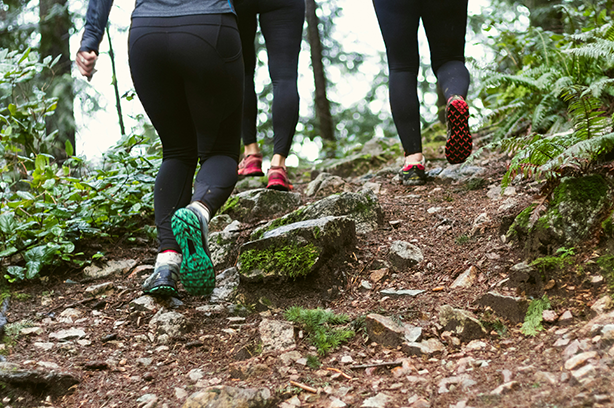 Photo by Greg Rosenke on Unsplash, group of athletic women in running shoes climbing a trail in the forest