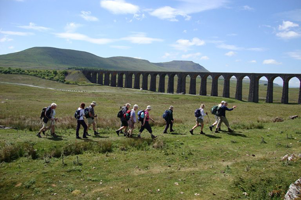 Photo taken by Community Rail Lancashire, walkers in front of Ribblehead Viaduct