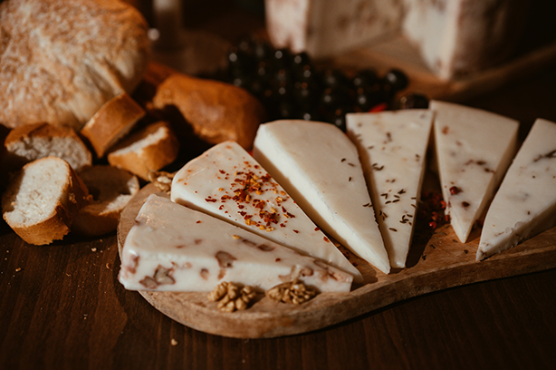 Photo by olimpia campean on Unsplash, cheese platter with chunks of bread on a wooden board