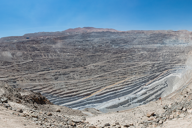 The Photo is by Diego Delso, CC BY-SA 4.0 - Panoramic view of Chuquicamata, a state-owned copper mine located at 2,850 metres (9,350 ft) above sea level just outside Calama, north of Chile. It is by excavated volume the largest open pit copper mine in the world.