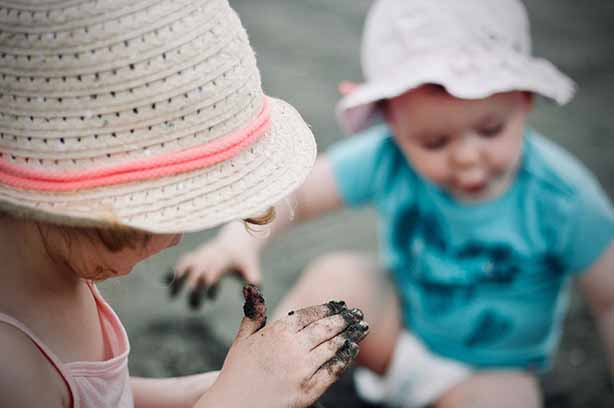 Photo by Jelleke Vanooteghem on Unsplash, kids playing in mud and sand