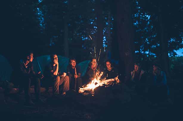 Photo by Mike Erskine on Unsplash, kids sitting around a campfire.