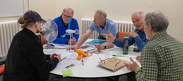 Energy workshop, attendees sat around a table making a wind turbine