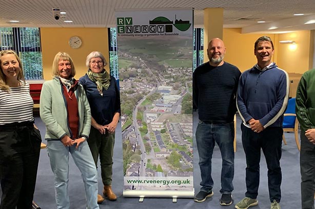 Staff from RV Energy, standing beside Net Zero Terrace Street in Rossendale banner