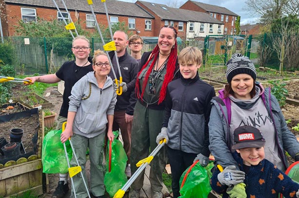 Guardians of Nature crew holding up tools on their allotment