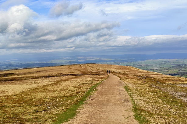 Photo by Amit Jagnade on Unsplash, people waking along a path in the Forest of Bowland National Park Clitheroe
