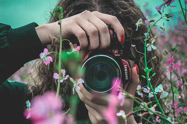 Photo by Nicolas Ladino Silva on Unsplash, female photographer taking pictures of flowers