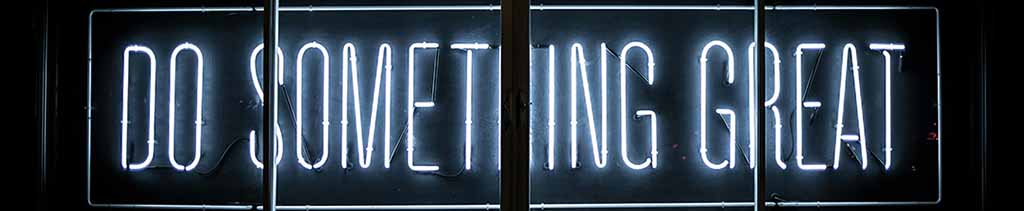 Photo by Clark Tibbs on Unsplash, 'Do Something Great' lit up in neon, white light on a black background