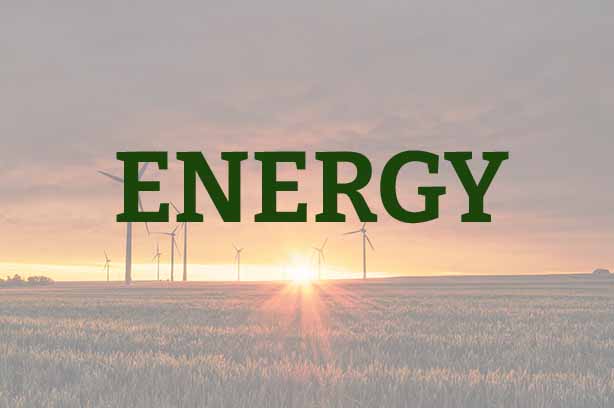 Photo by Karsten Würth on Unsplash, wind turbines in a field during sunrise, with 'energy' in the foreground