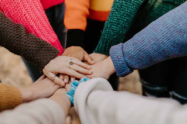 Photo by Hannah Busing on Unsplash, hands coming together in a centre down clap