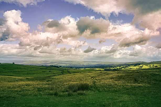 Photo by Niklas Weiss on Unsplash, view of Cumbria's green hills and countryside