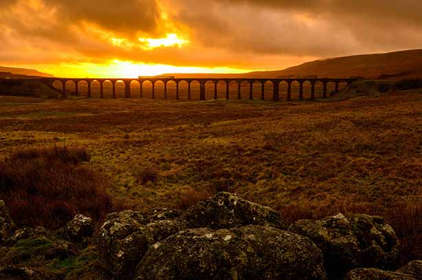 Photo by Mark mc neill on Unsplash, train crossing the ribblehead viaduct at sunset