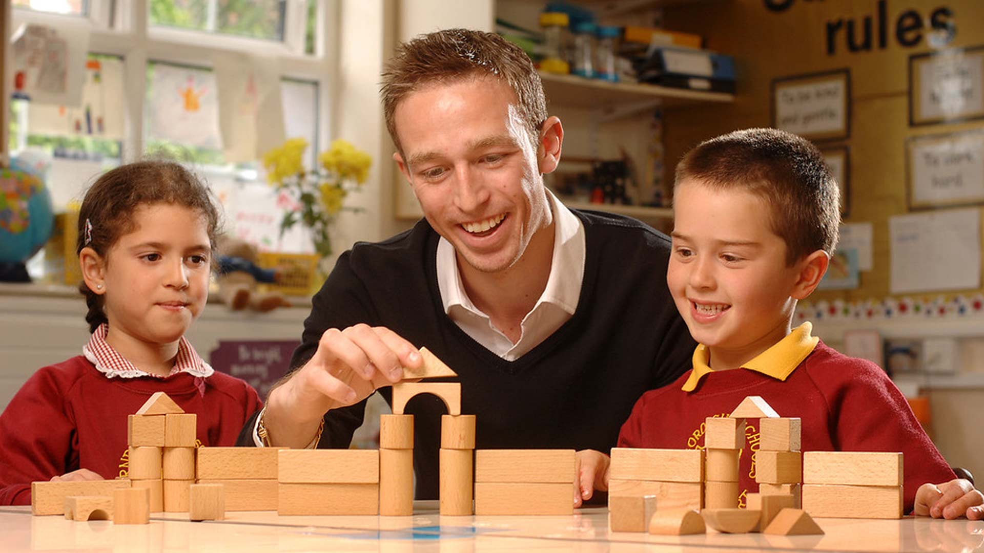 A tutor and two primary school students build with blocks during a Design and Technology class