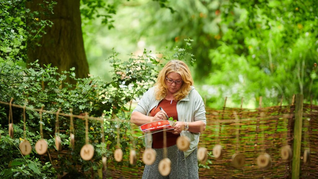 A tutor organising wooden phonics for an outdoors learning session