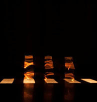 A dark, empty stage with golden blocks of light.