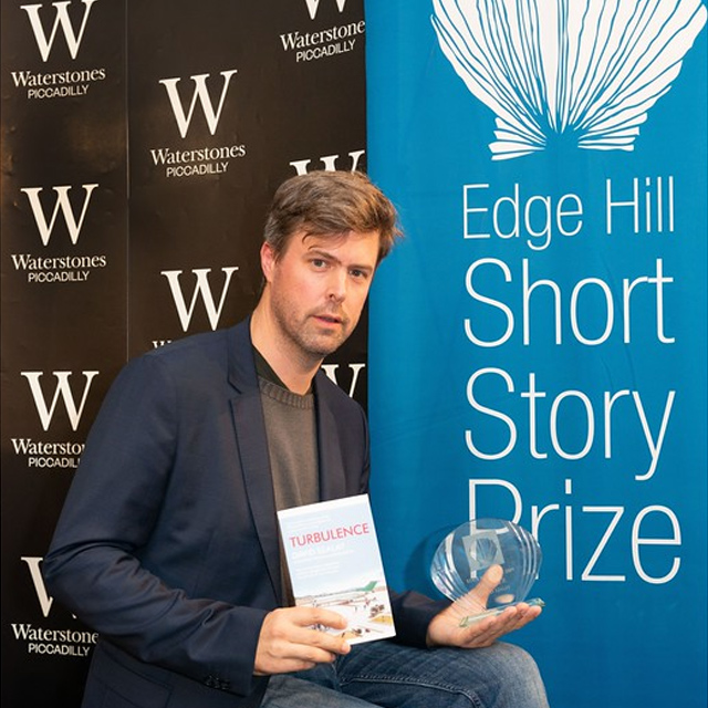 David Szlay holding his Edge Hill Short Story prize