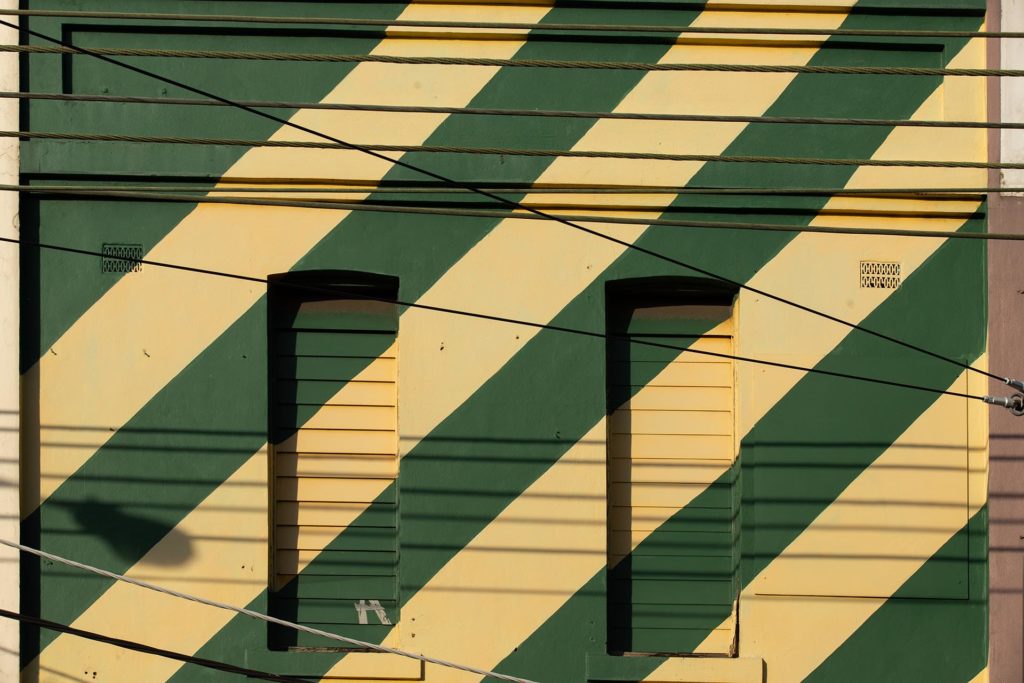 Urban photo of the side of a green and yellow striped building