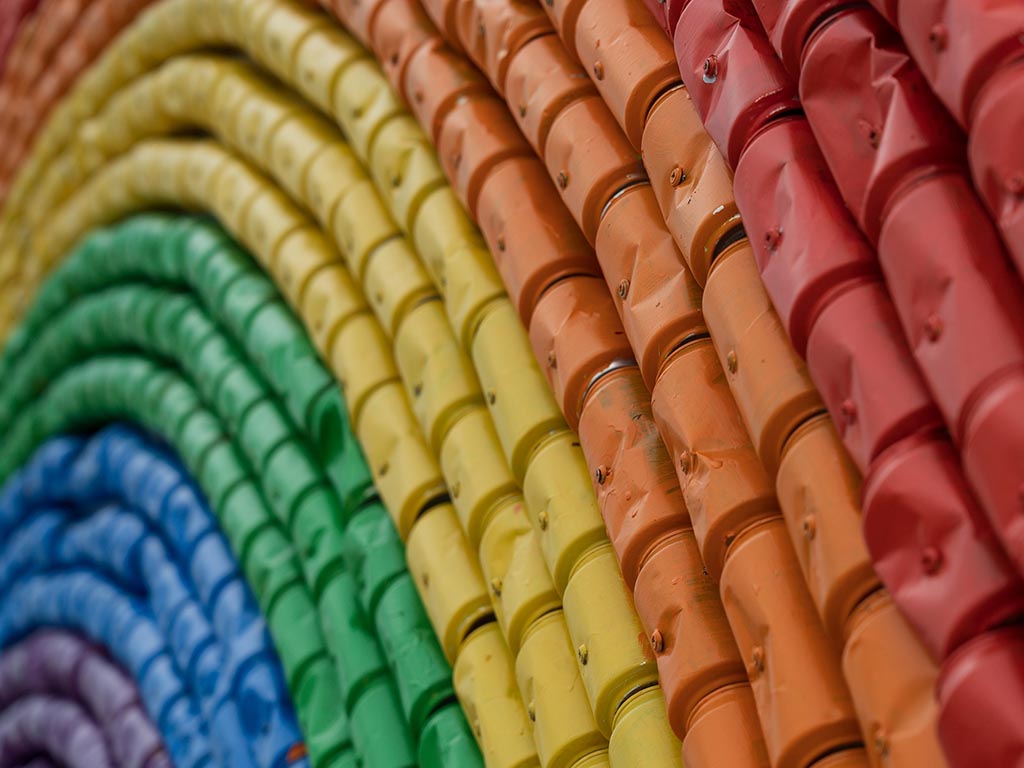 Soda cans painted the colours of the rainbow whilst arranged to create a rainbow