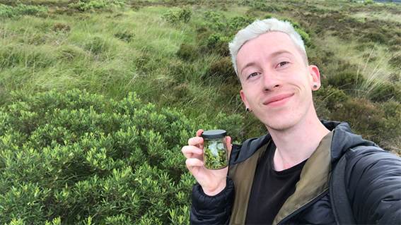 Joshua Styles holding a jar of moss