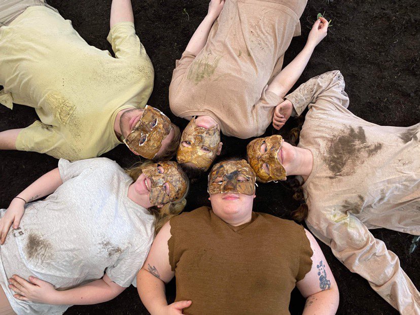 Tenderfoot theatre actors wearing masks while lying on the floor in a circle