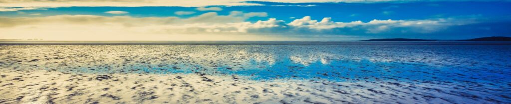 Photo by Jonny Gios on Unsplash - across the bay towards Silverdale coastal sand dunes
