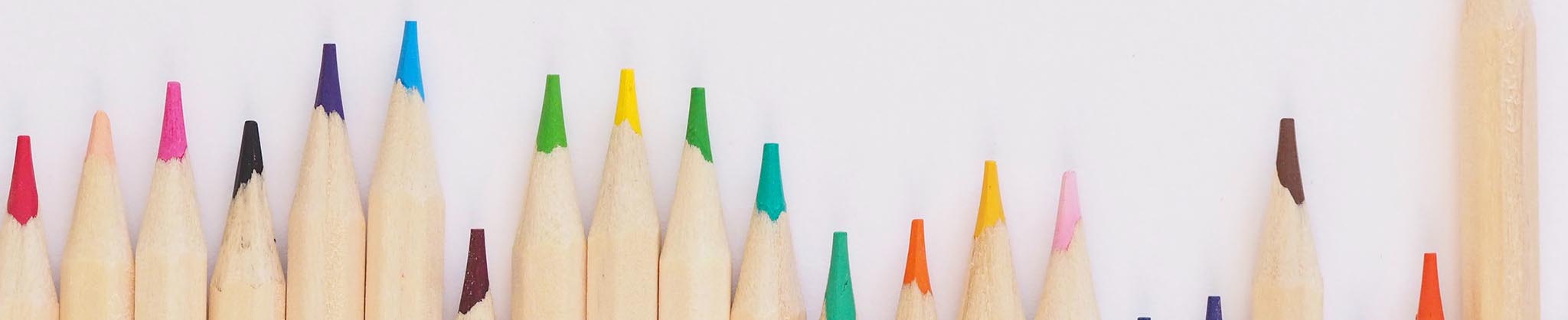 Multi-coloured pencils in an undulating row - Photo by Jess Bailey on Unsplash