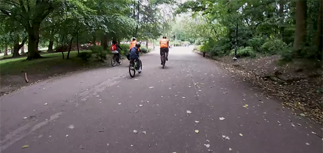 Three cyclists riding through Sefton Park