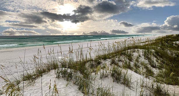Sun rising beyond the sea and sand dunes