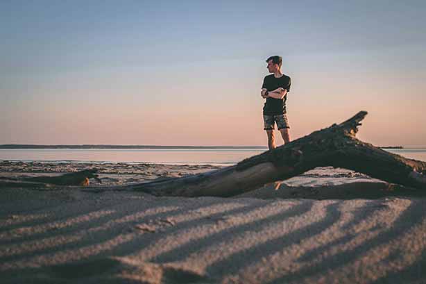 Photo by Taras Chernus on Unsplash, man standing near shore